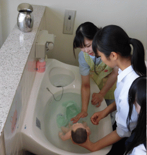 学生と参加者が新生児の沐浴をしている