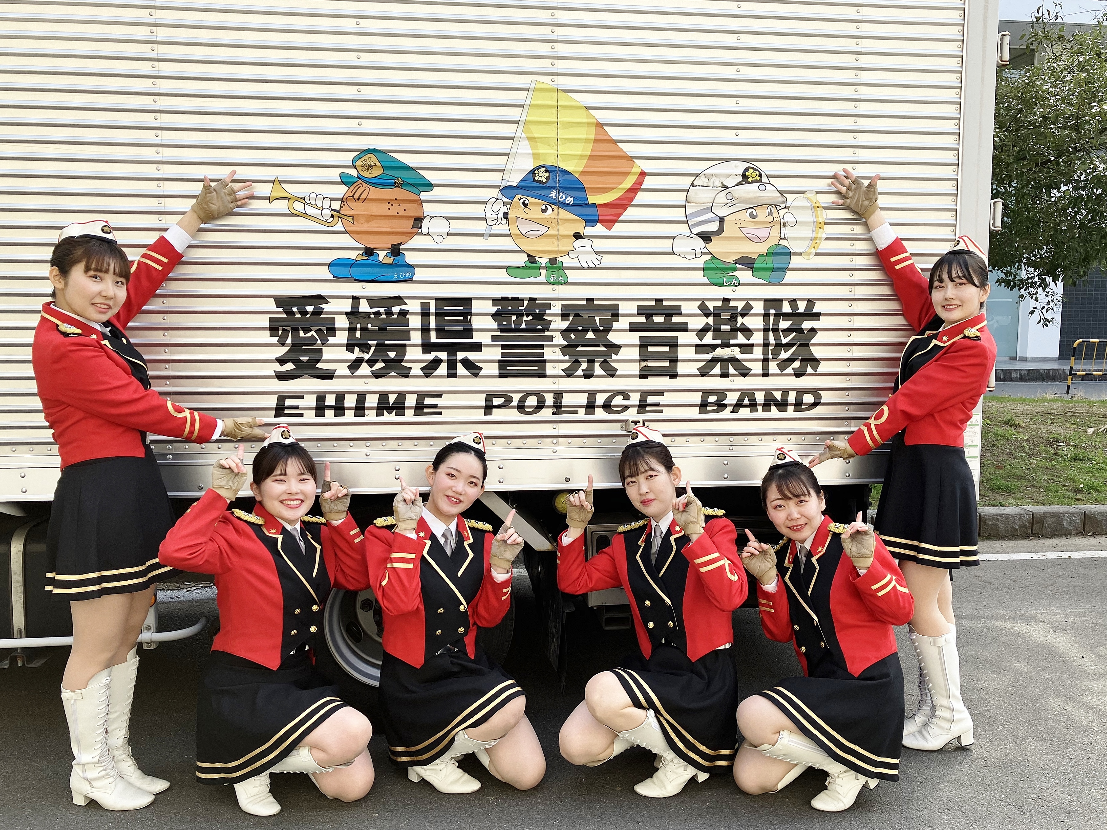 愛媛県警察員楽隊ロゴの前で記念撮影