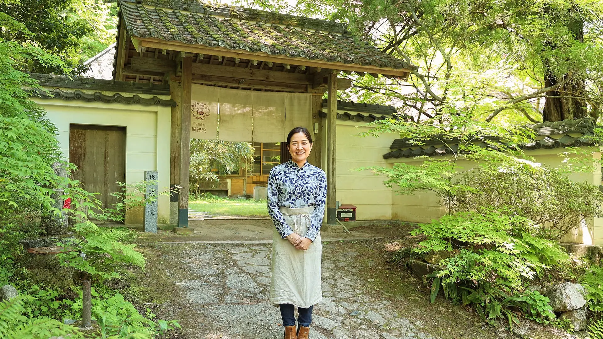 日本茶カフェ「雪月風花 福智院」の前で笑顔の吉宗さん