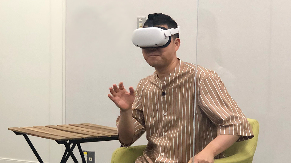 ゴーグルをつけてVR動画を体験する中島尚樹さん