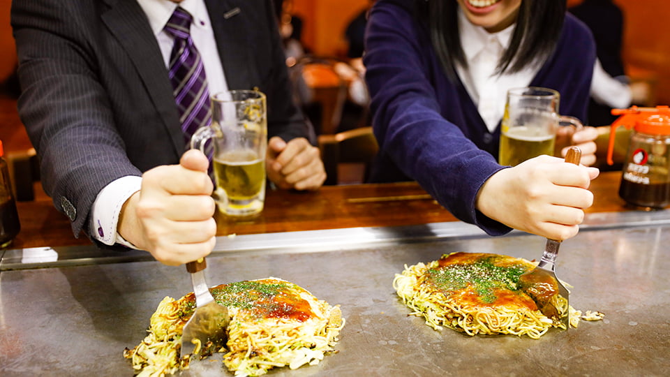 お好み焼を楽しむ人々