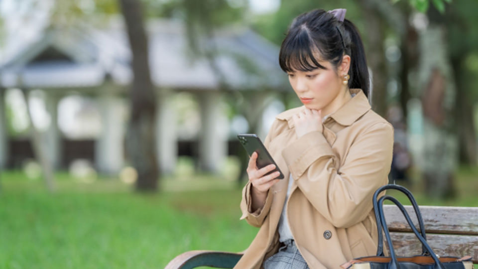 スマホを見て考える女性 イメージ