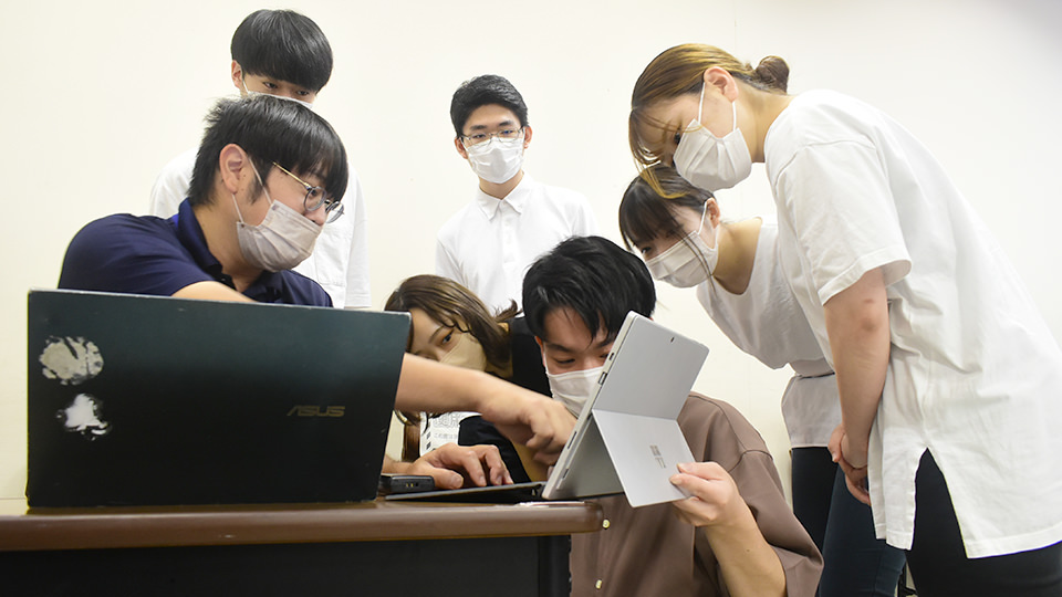 熱心にパソコンを見つめる学生