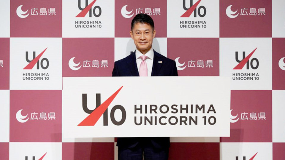ユニコーン10プロジェクトのロゴを持つ湯崎知事