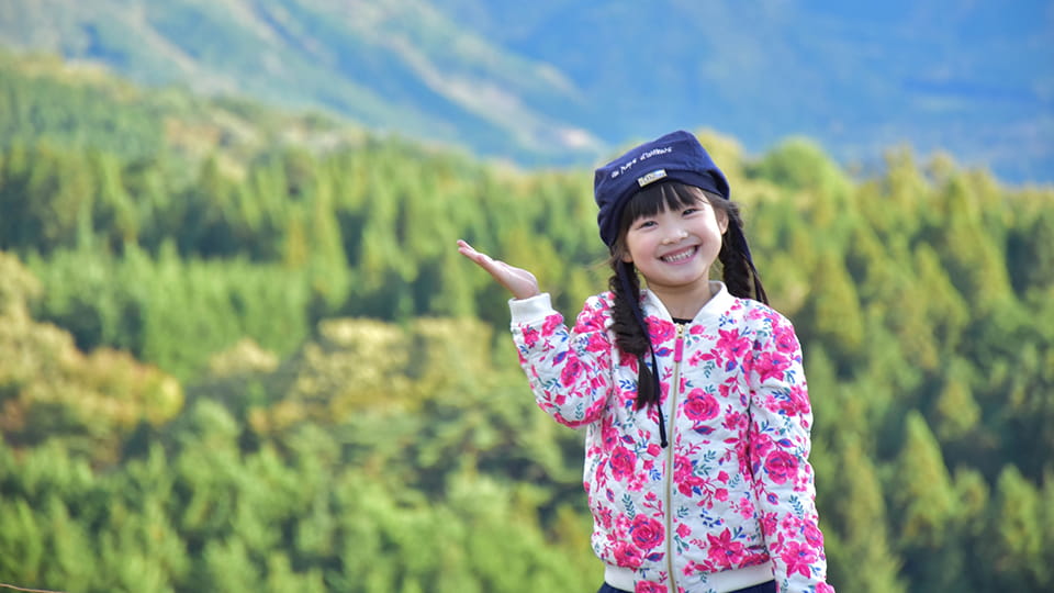 背景の森を紹介する少女
