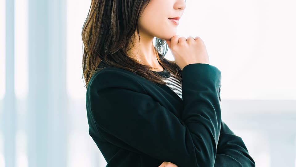 顎に手を当て考える女性