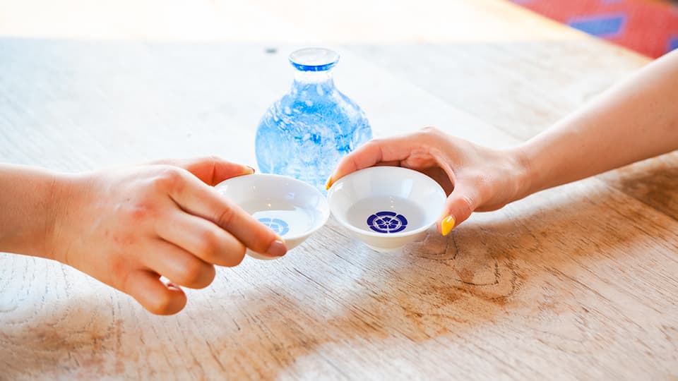 おちょこで乾杯する様子