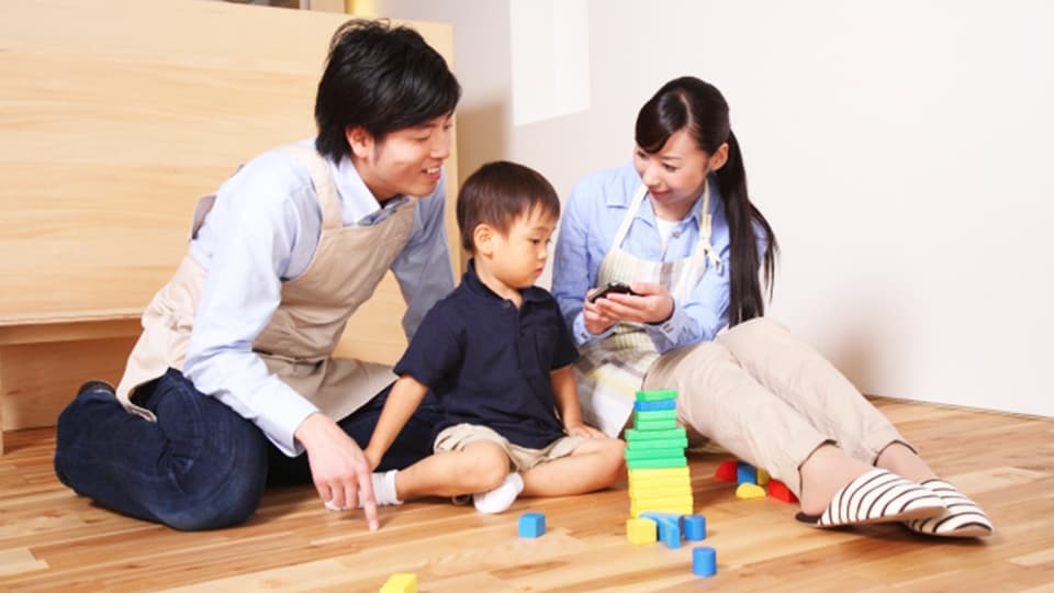 積み木で遊ぶ親子3人