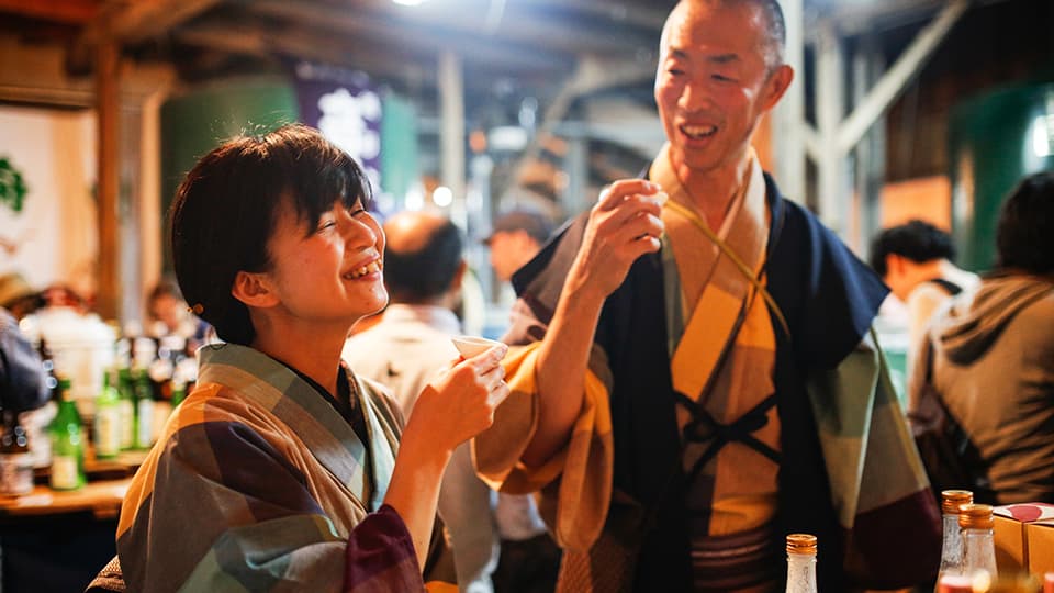 笑顔で日本酒を楽しむ2人