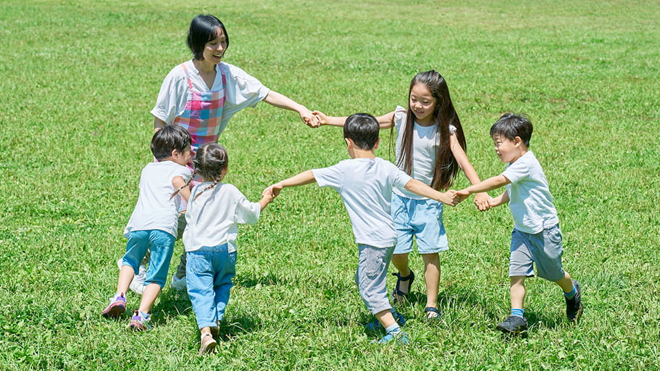 子供達と手をつなぐ保母さん