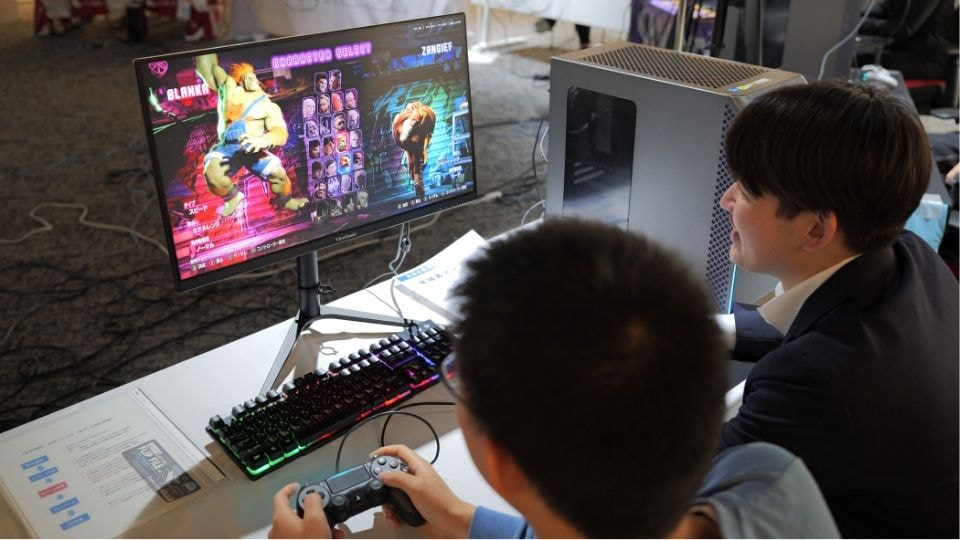 対戦ゲームをプレイする学生と企業の社員