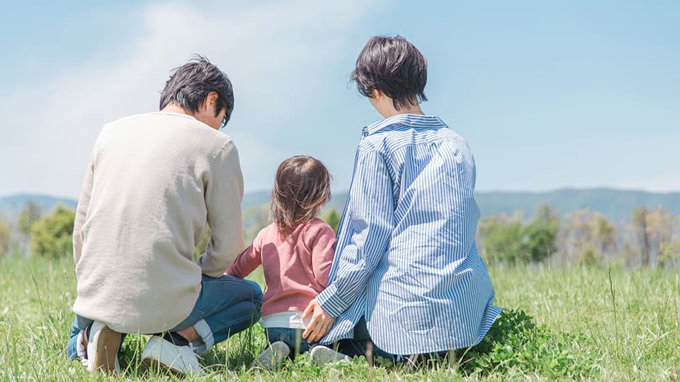 女の子とその両親の後ろ姿