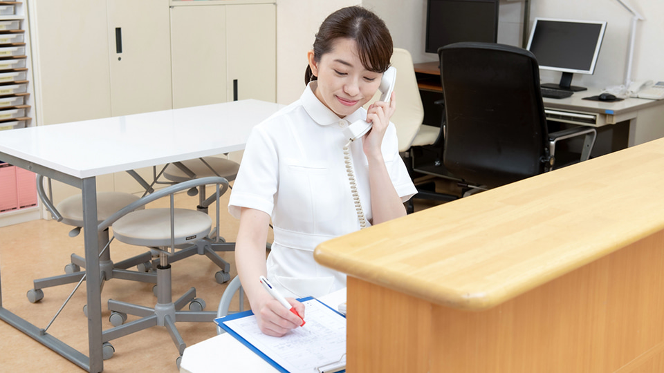 電話を受けるナースの女性