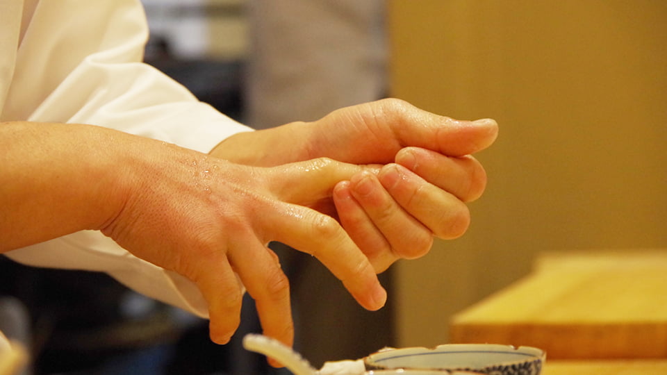 鮨を握る職人の手