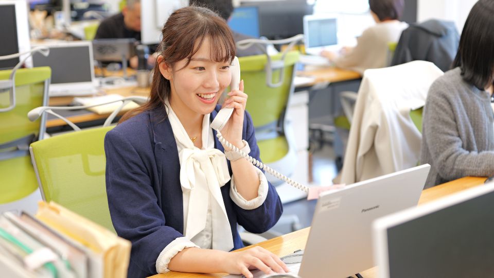 職場で電話を受ける女性
