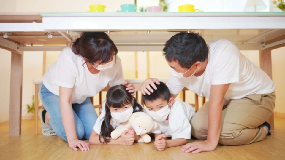 机の下に隠れる家族