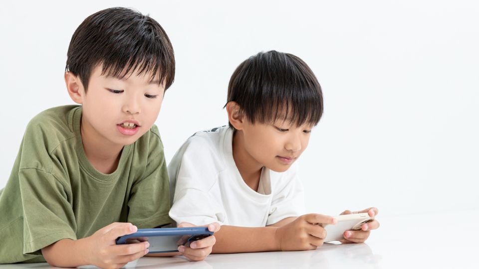 スマホゲームをする二人の子供