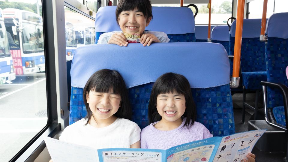 笑顔でバスに乗っている3姉妹