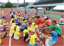 子供たちと一緒にストレッチしている写真