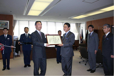 交通安全活動に寄与されたマツダ(株)に対し，宮園本部長（写真左側）から金井会長（写真右側）へ感謝状を贈呈