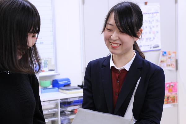 同僚と話をしている女性の事務職員