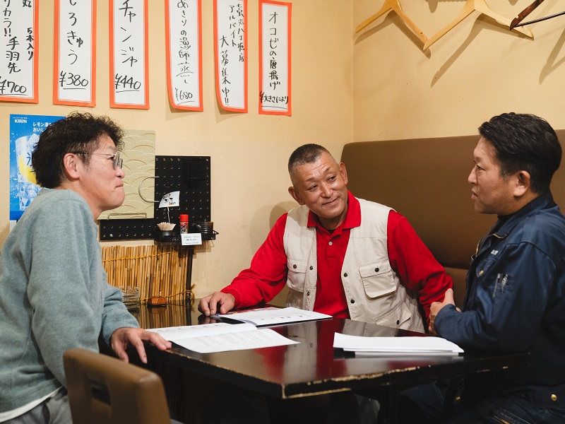 居酒屋で語り合っている３名の漁師さん