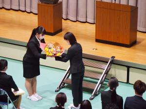 在校生代表が卒業生に花束を渡している様子です。