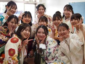 袴を着て髪をきれいに飾った卒業生がカメラに向かってピースサインをしています。