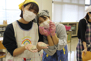 餃子を包んでいます。とても上手に包めてうれしそうな学生が2名映っています。