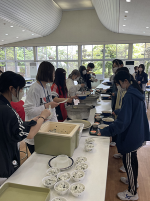 全員でご飯を食べるために食材をよそっている様子
