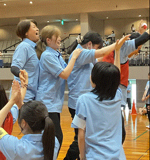 学生がムカデ競走で一番にゴールして喜んでいる