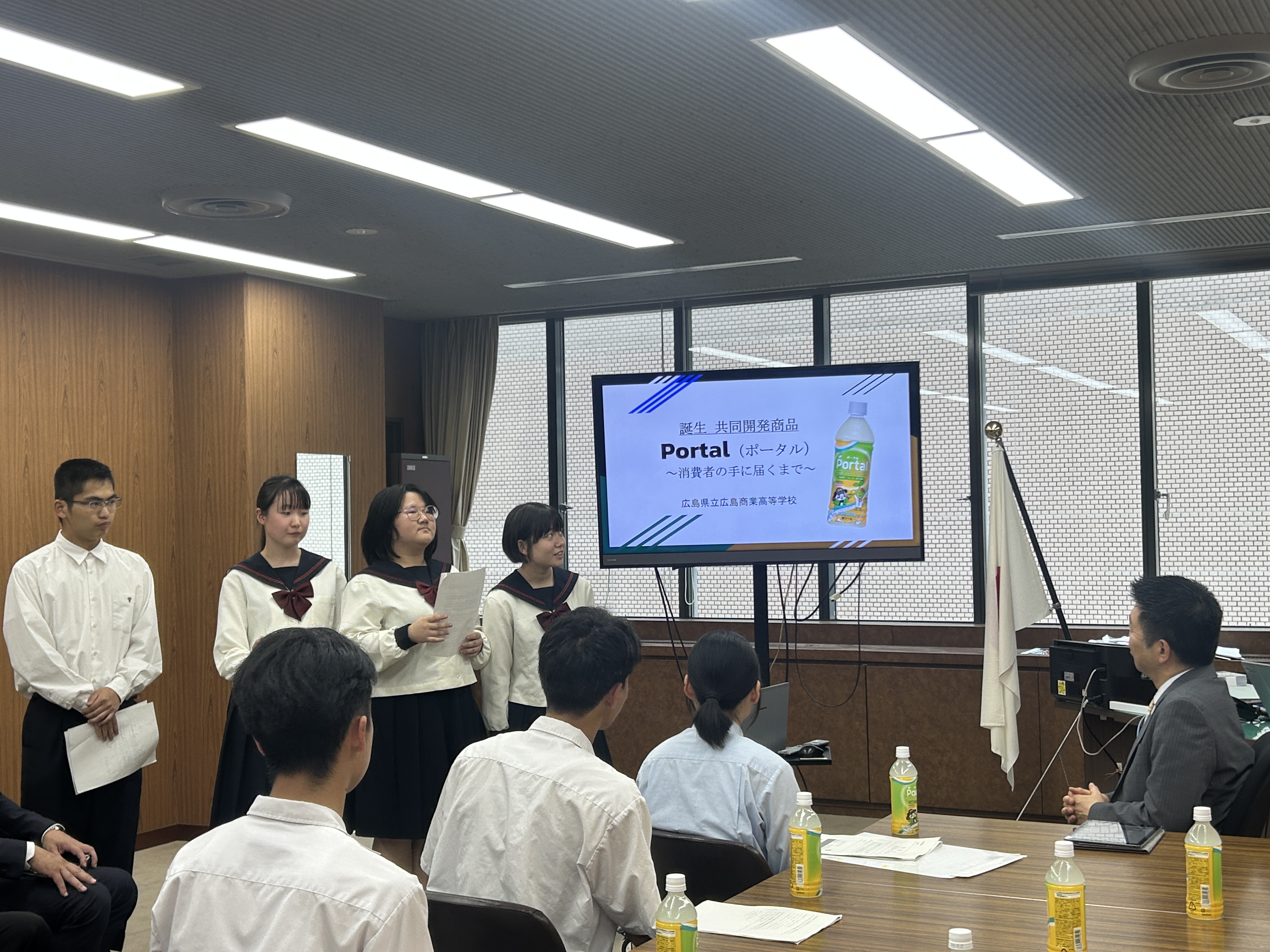 教育長にプレゼンテーションをする広島商業高校生徒