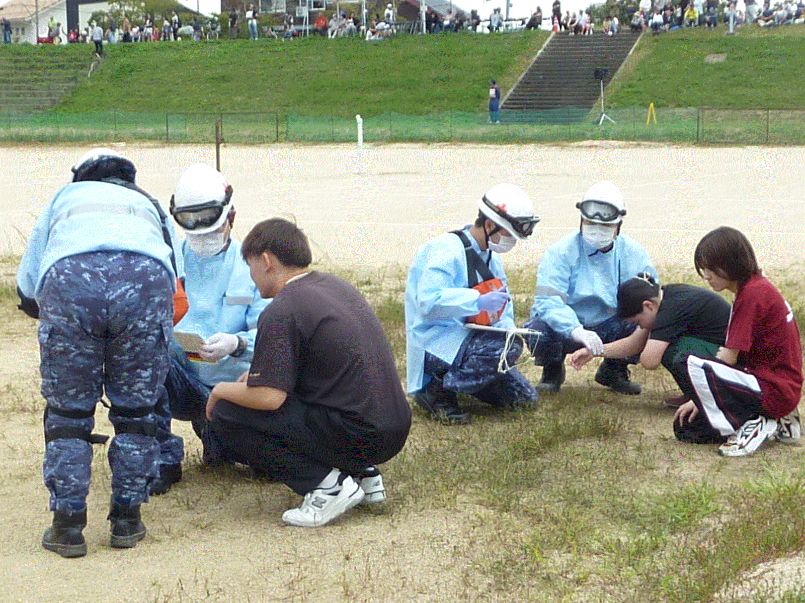 患者役の学生が被災現場で救急隊員に状態を確認されている