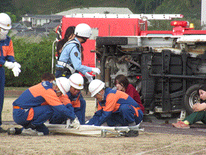 患者役の学生が警官や消防隊員に状況を説明している