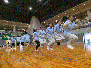 長縄まわしの競技で学生が飛び上がっている